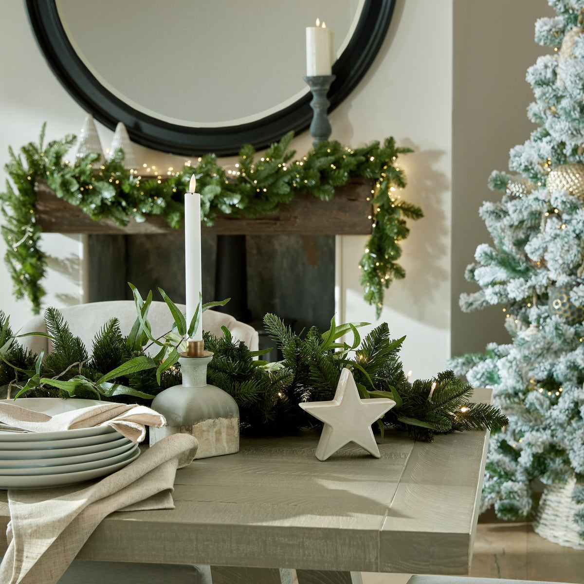 Decorative Christmas setting with a table, tree, and fireplace.